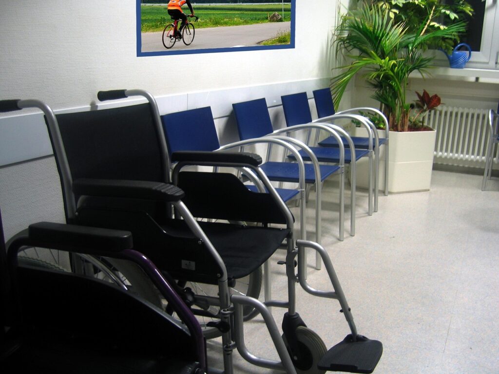 Empty clinic waiting area with chairs and a wheelchair