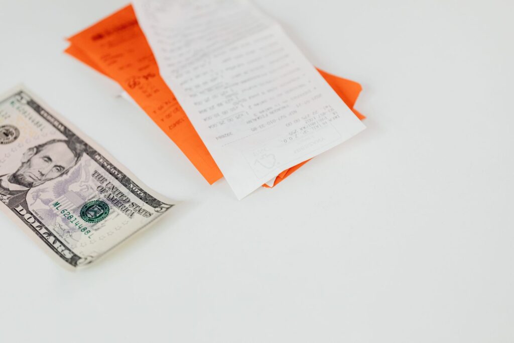 Banknote and printed receipts lying on a plain white surface